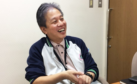 浅野事務長のインタビュー中の笑顔の写真